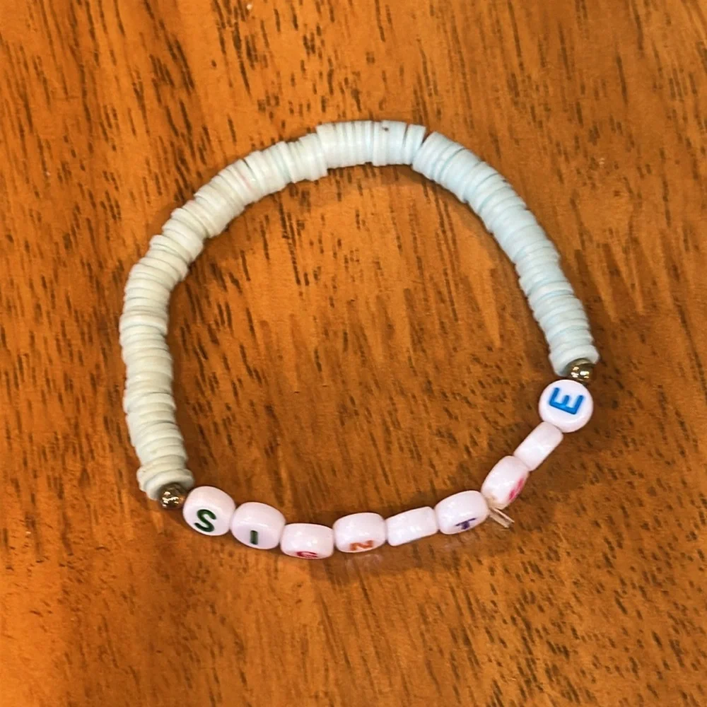 Kids shell bracelet with the word “signature”. Light teal shells.